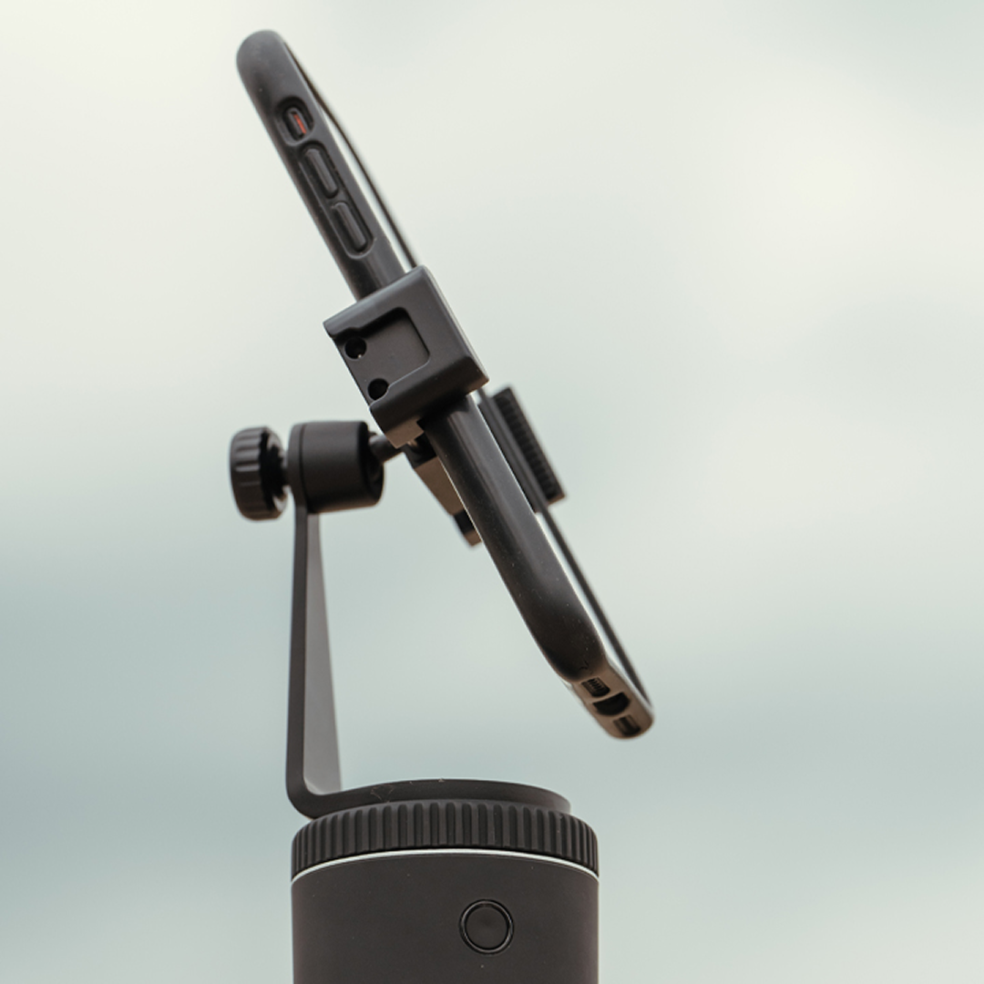 Adjustable smartphone mount on tripod, tilting forward and backward for versatile angle capturing.