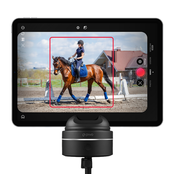 Pivo Pod Max tenant une tablette qui suit automatiquement un cheval bai et son cavalier dans un manège